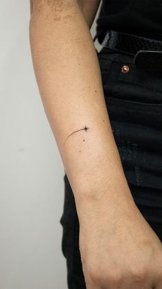 a person's arm with a small star tattoo on it