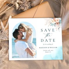 save the date card with an image of a man and woman hugging each other in front of some feathers