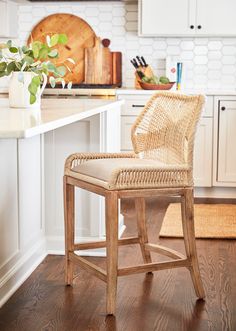 a wicker chair sitting on top of a wooden floor next to a kitchen counter