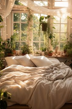 an unmade bed with white sheets and pillows in front of a window filled with potted plants