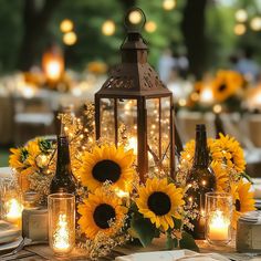 a table with sunflowers, candles and wine bottles is set up for an outdoor dinner