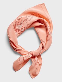 an orange scarf with paisley designs on the front and side, tied in a knot