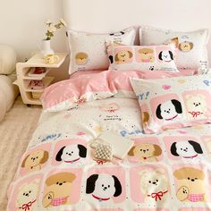 a bed covered in pink and white sheets with cartoon dogs on them, along with matching pillows