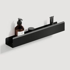 a black shelf with soap and lotion on it