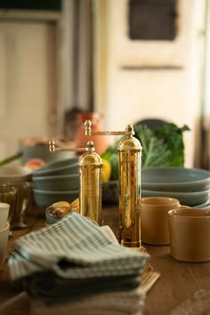 a wooden table topped with dishes and cups