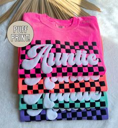 Our retro checkered auntie shirt is the perfect gift for all the new aunt's out there! Made on the soft comfort colors brand, these puff print tees are sure to be a summer favorite for all the auntie's! ★UNISEX T-SHIRTS-Run true to size.  If wanting a more oversized look, selecting 1 or 2 sizes up is recommended. ★How to order- 1. Select Size and Shirt Color-add to cart. 2. If wanting a different text (other than auntie)-click "add personalization" - enter custom text. Click add to cart. ★Care I Easy Shirt Designs Cricut, Auntie Tee Shirts, Personalized Shirt Ideas, Puff Vinyl Shirt Designs, Puff Print Design, Oversized Tshirt Design Ideas, Puff Vinyl Ideas, Tshirt Print Ideas Graphic Tees Shirt Designs, Puff Vinyl Shirt Ideas