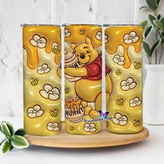 three yellow tumblers with winnie the pooh on them