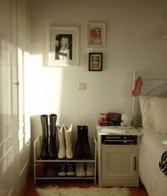 a bedroom with white walls and pictures on the wall next to a shoe rack filled with shoes