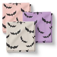 three different colored bat patterned napkins sitting on top of each other