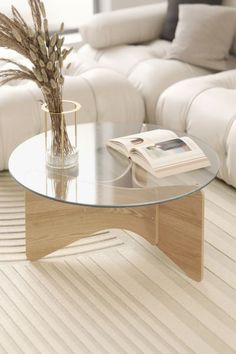 a glass coffee table sitting in front of a white couch