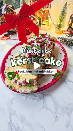 a red plate topped with cake covered in frosting and sprinkles next to a christmas tree