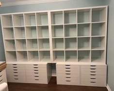 a white bookcase with many drawers in it