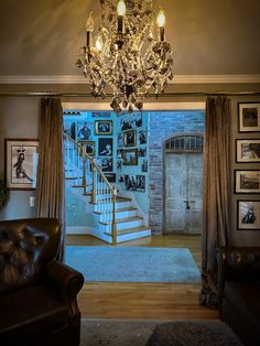 a chandelier hangs from the ceiling in front of a doorway leading into a living room