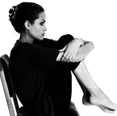 a woman sitting in a chair with her legs crossed