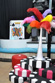 colorfully decorated tables and stools in front of a stage