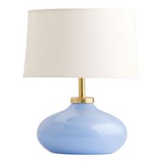 a light blue table lamp with a white shade on the bottom and a gold base