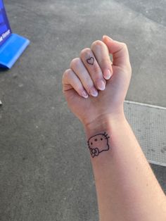 a person with a small tattoo on their wrist holding the hand of another person's arm