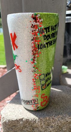 a cup that is sitting on top of a cement block in front of a fence