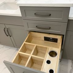 an open drawer in the middle of a kitchen countertop with drawers on both sides