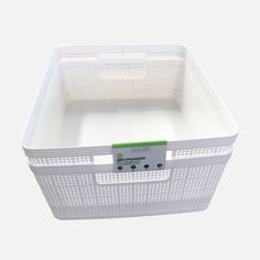 a white plastic container with a green label on the lid and side opening for storage