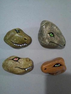 four different sized rocks with green eyes on them