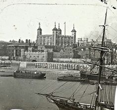 an old black and white photo of ships in the water next to a large building