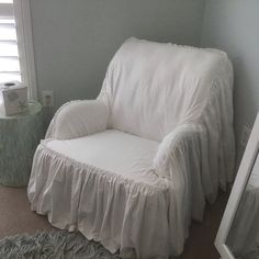 a white chair with a ruffled cover on it's back in a room