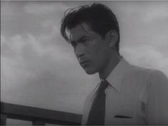 black and white photograph of man in dress shirt and tie looking off into the distance