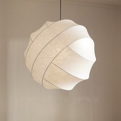 a white lamp hanging from a ceiling in a room with no one around it,