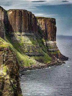 the cliffs are covered in green grass near the ocean