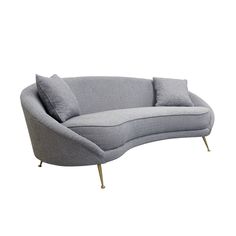 a grey couch with two pillows on it and some metal legs in front of the couch