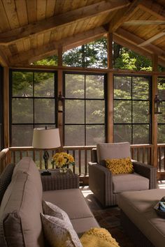 a covered porch with couches and lamps