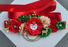 a close up of a red ribbon with flowers and bells on it's side