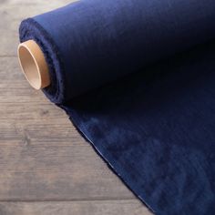 a roll of blue fabric sitting on top of a wooden floor