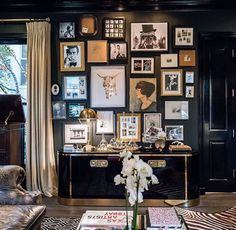 a living room filled with furniture and pictures on the wall