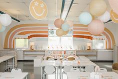 the inside of a restaurant with tables, chairs and paper lanterns hanging from the ceiling