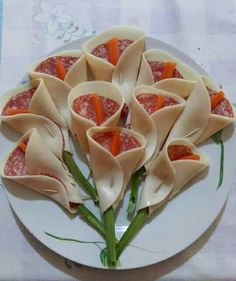 a white plate topped with wontons covered in meat and veggie sauce