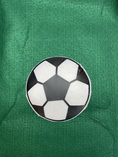 a black and white soccer ball on a green surface