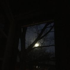 the full moon is seen through an open window at night with no one in it