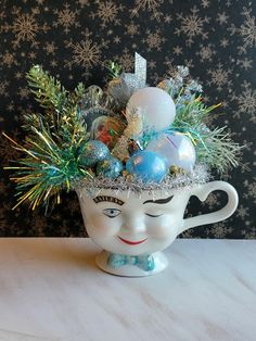 a white cup filled with ornaments on top of a table