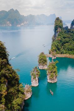 an aerial view of several small islands in the water with boats floating on top of them