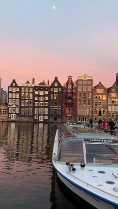 a boat is docked in the water next to some buildings