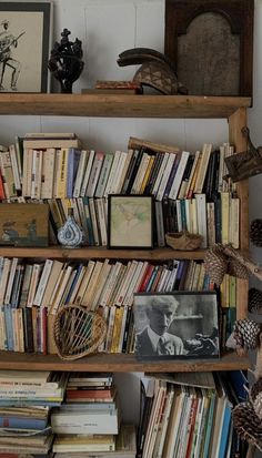 a bookshelf filled with lots of books next to a clock and other items