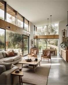 a living room filled with lots of furniture and large glass windows on top of it