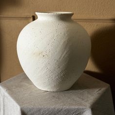 a white vase sitting on top of a table