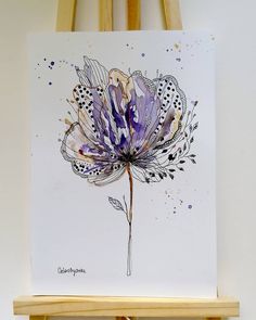 a purple and white flower is on a easel