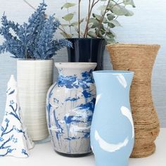 four vases with different designs and words on the front one has blue flowers in it