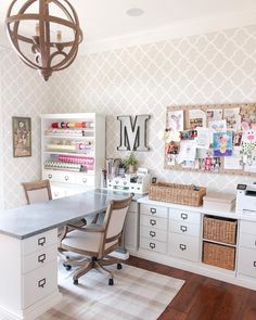 a home office with white cabinets and drawers