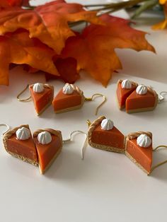 several pieces of pie with white frosting on them sitting next to some autumn leaves