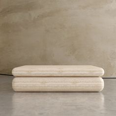 two white marbled objects sitting next to each other in front of a concrete wall